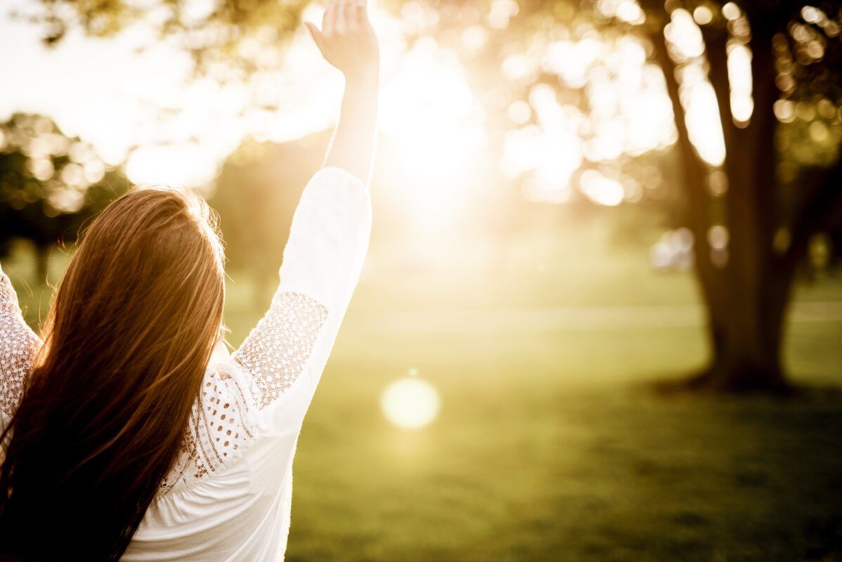 Mujer conectando con la naturaleza y la energía vital a través del masaje TNDR.